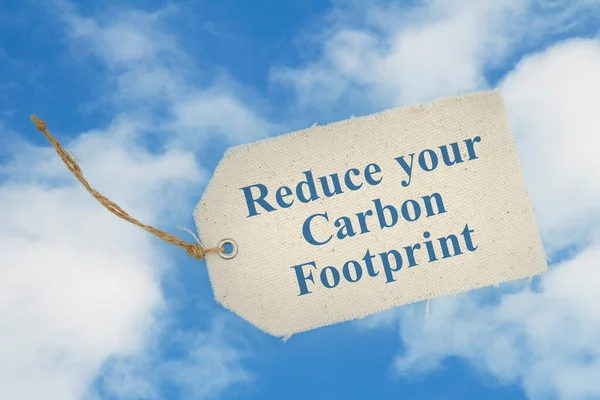 Reduce your carbon footprint message on cloth gift tag on blue sky