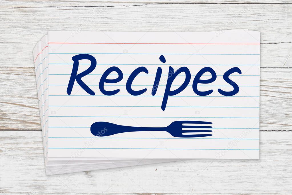 Recipes message on white paper index cards with a fork on wood