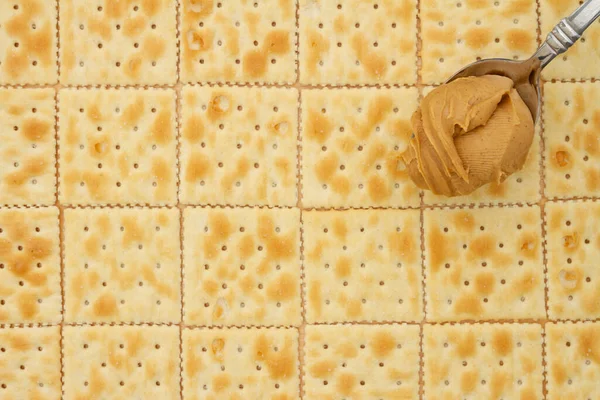 Saltine Crackers Achtergrond Met Lepel Vol Pindakaas Met Kopieerruimte Voor Stockafbeelding