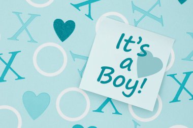 Its a boy message on a sticky note on blue hearts paper