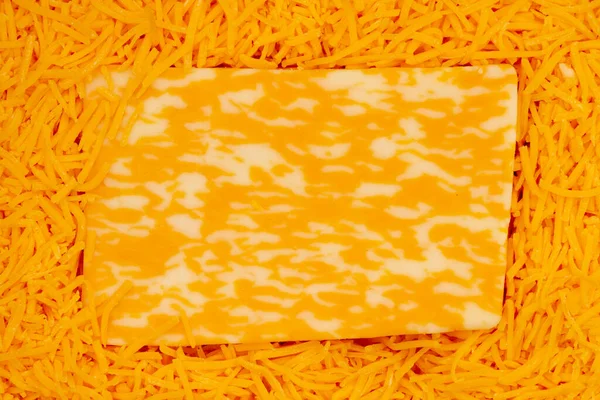 あなたのスナックメッセージのためのコピースペースと千切りチェダーチーズの背景にチーズのブロック — ストック写真