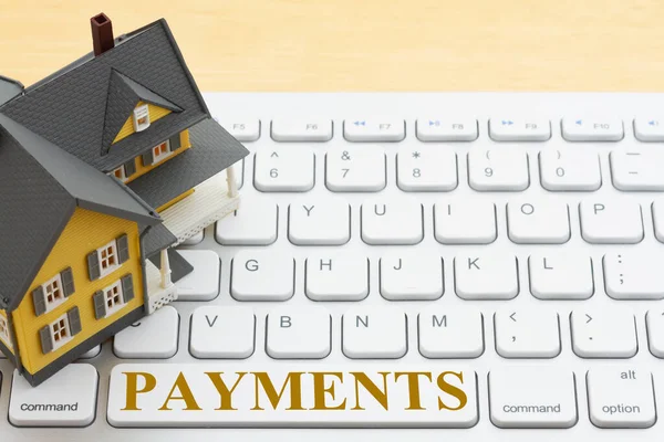 住宅ローンの支払いをオンラインで計算するためのグレーのキーボードのモデルハウスとの支払いメッセージ — ストック写真