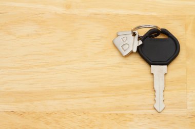 Emlak mesajı almak ya da satmak için ahşap masadaki anahtarlığın üzerindeki model ev.