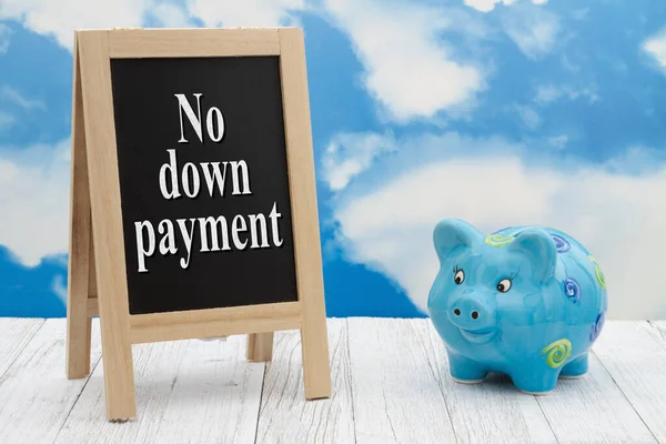 No down payment message standing chalkboard with a piggy bank on weathered wood with clear sky