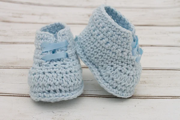 Botines de bebé azul pálido sobre fondo de madera — Foto de Stock