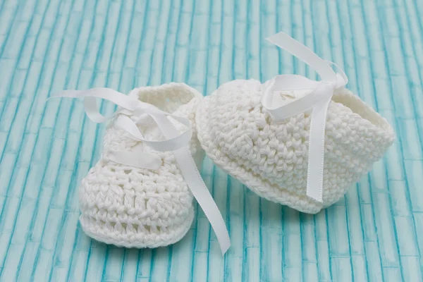 White Baby Booties on wood background — Stock Photo, Image