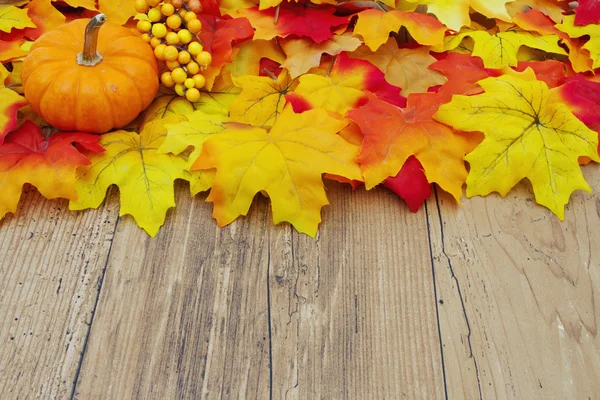 Foglie di autunno e zucca su uno sfondo di legno meteo — Foto Stock