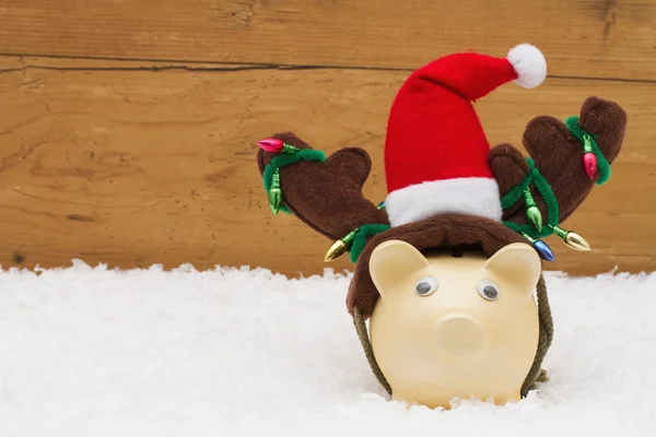 Karácsonyi megtakarítások, Piggy Bank a rénszarvas agancs a hó wit — Stock Fotó