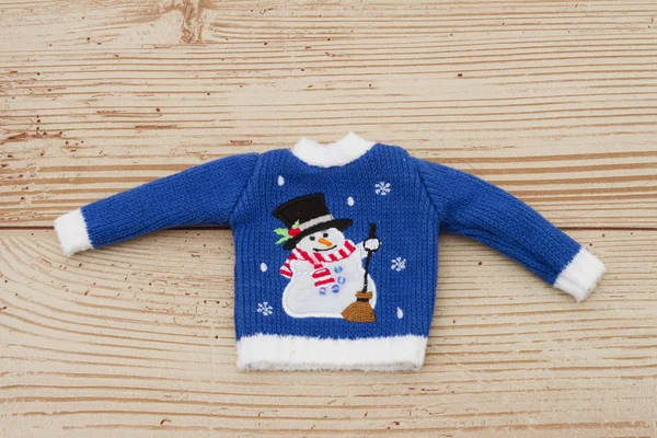 Blauwe en witte Snowman Christmas trui op een houten Backg weer — Stockfoto