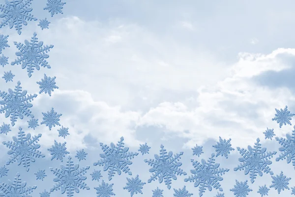Blauwe sneeuwvlokken met wolken achtergrond — Stockfoto