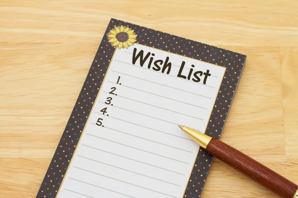 Un bloc-notes et un stylo sur un bureau avec texte Liste de souhaits et espace de copie — Photo