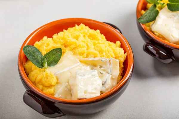 Erimiş gorgonzola peynirli bir tabak polenta.