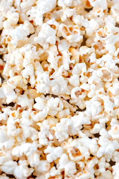 Masada tuzlanmış patlamış mısır var. Seçici odaklanma. Düz yatıyordu. Rahatlama ve dinlenme kavramı. Dikey yönelim.