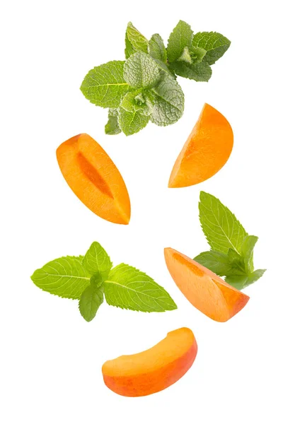 Falling down mint herb and apricots isolated on white background — Stok Foto