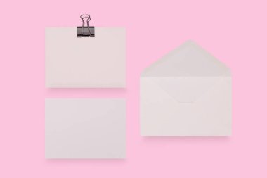 Pembe arka planda boş kart ve zarf