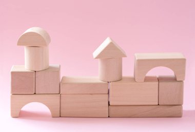 Soyut geometrik gerçek ahşap küp pembe arka planda sürreal bir düzen ile