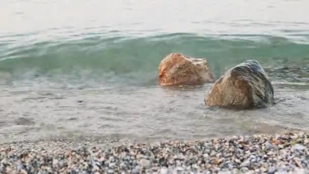 Des vagues battent contre des rochers sur la rive du lac — Video