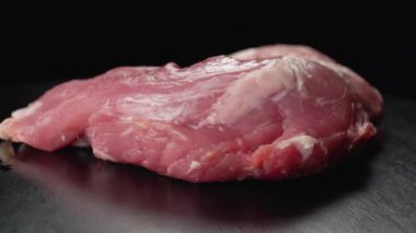 Çiğ et. Siyah arka planda domuz filetosu.