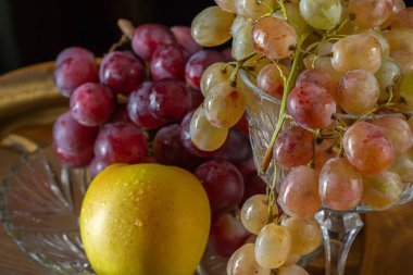 Siyah arkaplanda elmalar ve üzümler.