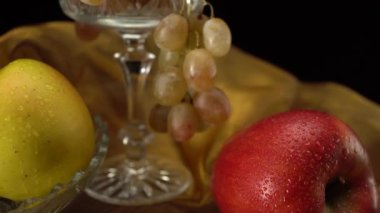 Siyah arkaplanda elmalar ve üzümler.