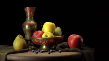 Siyah arka planda elmalar ve armutlarla dolu bir hayat.