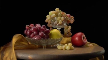 Siyah arkaplanda elmalar ve üzümler.