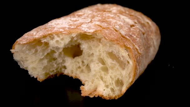 Ciabat bread on a black background close-up. — Stock Video