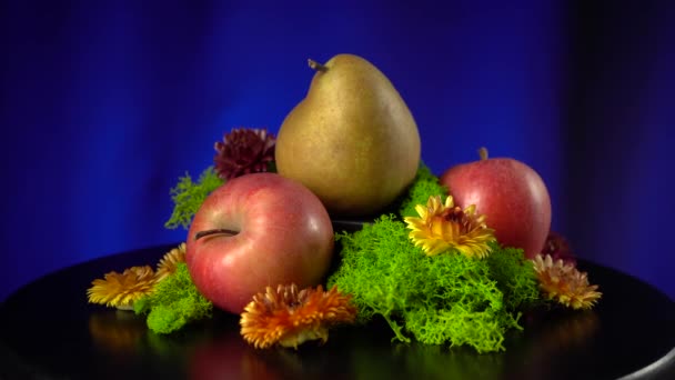 Složení hrušek, jablek, mechu a žlutých květů. — Stock video