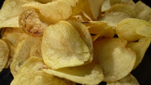 Croustilles de pommes de terre sur fond noir gros plan. — Video