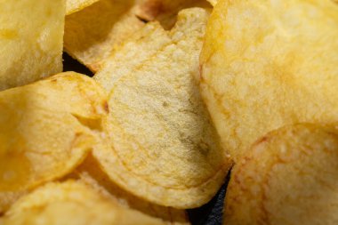 Siyah arka planda patates cipsi. Yakın plan..