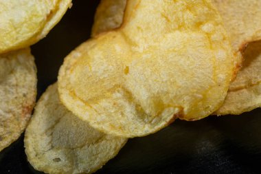 Siyah arka planda patates cipsi. Yakın plan..