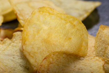 Siyah arka planda patates cipsi. Yakın plan..