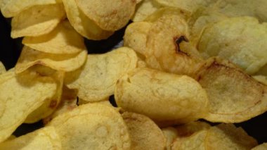 Siyah arka planda patates cipsi. Yakın plan..