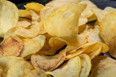 Siyah arka planda patates cipsi. Yakın plan..