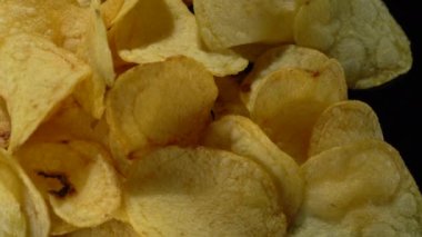 Siyah arka planda patates cipsi. Yakın plan..