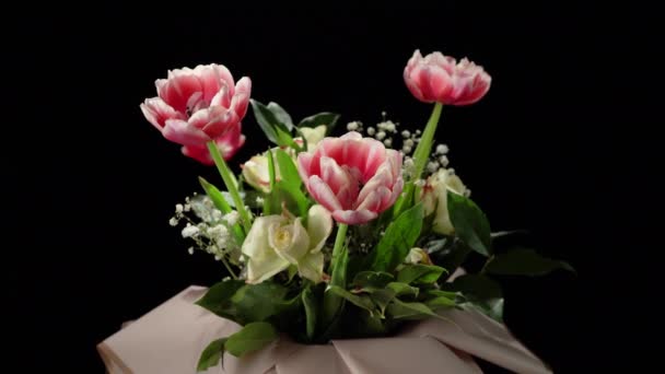 Blumenstrauß auf schwarzem Hintergrund. Rote und weiße Tulpen und weiße Rosen. — Stockvideo