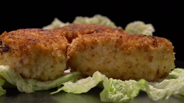 Stir-fried turkey cutlets on lettuce leaves on a black background. — Stock Video