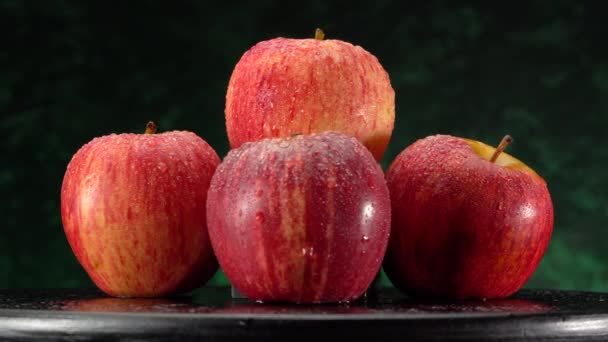 Su damlacıklarıyla kırmızı-yeşil bir elmaya yakın çekim makro çekim. — Stok video