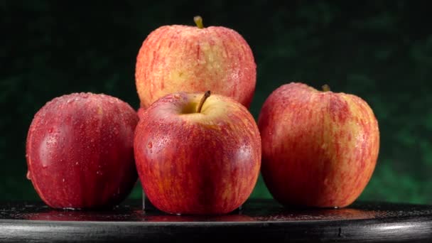 Gros plan d'une pomme rouge-verte avec des gouttelettes d'eau macro shot. — Video