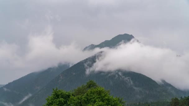 Berg toppar mot bakgrund av snabbrörliga moln. — Stockvideo