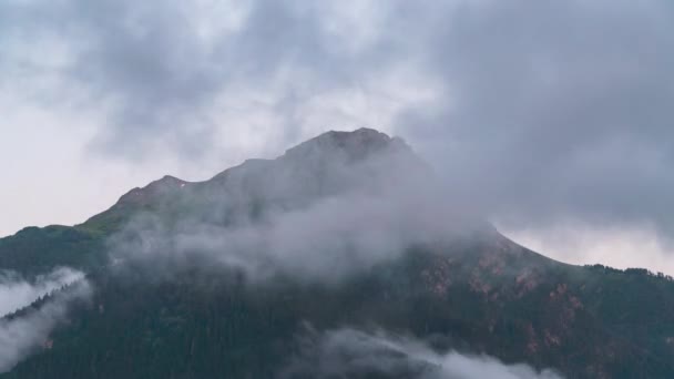 Berg toppar mot bakgrund av snabbrörliga moln. — Stockvideo