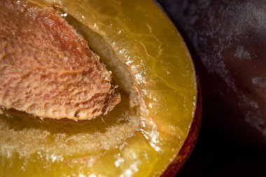 Tahta bir masanın üzerinde sulu olgun erikler..