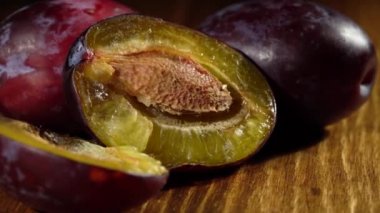 Tahta bir masanın üzerinde sulu olgun erikler..