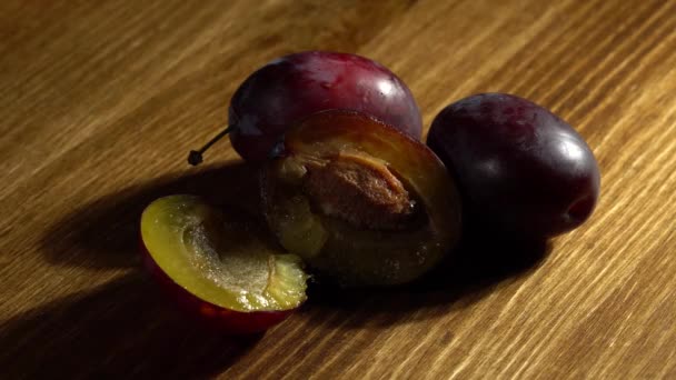 Saftige reife Pflaumen aus nächster Nähe auf einem Holztisch. — Stockvideo