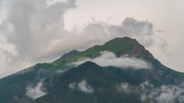 Hızla hareket eden bulutların arka planına karşı dağ zirveleri. — Stok video