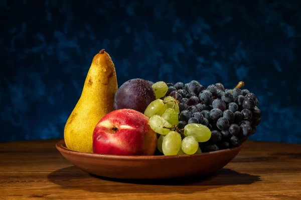 Zátiší s ovocem. Hrozny, nektarinky, hrušky a švestky. — Stock fotografie