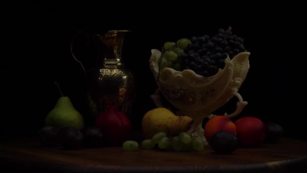 Nature morte avec des fruits sur une table ronde en bois et fond noir. — Video