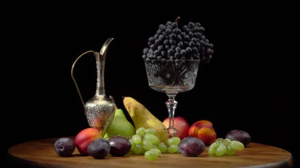 Stillleben mit Früchten auf rundem Holztisch und schwarzem Hintergrund. — Stockvideo