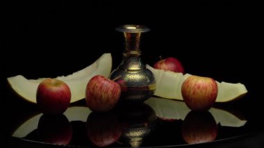 Kesik karpuz ve siyah arkaplanda elmalarla dolu bir hayat