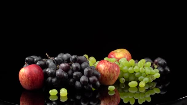 Bodegón con uvas y manzanas sobre fondo negro. — Vídeos de Stock